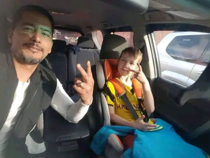 A child in a child seat with the driver in the car