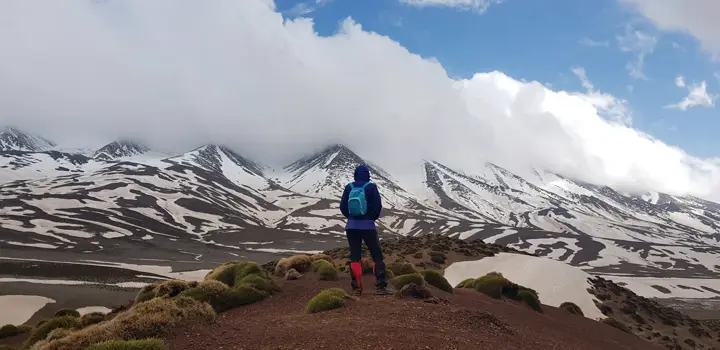 Hiker in front of the snowy peaks of the High Atlas