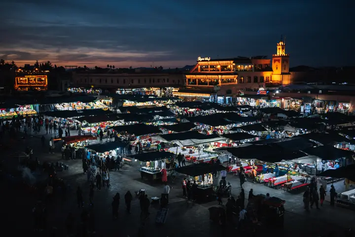 Jemaa el-Fna square in Marrakech in the evening, with food stalls and the Koutoubia