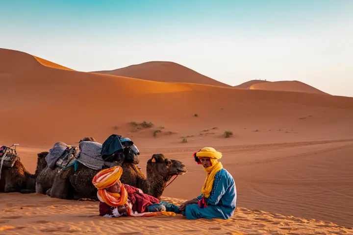 Berber with camels in the dunes of Merzouga